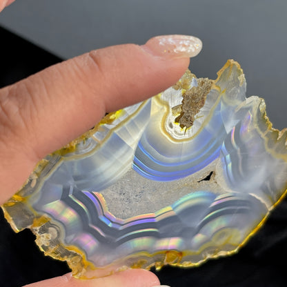 虹彩瑪瑙是一種細帶狀、半透明的石髓 (Chalcedony)，並且可將透射光分解成為光譜顏色。”Iris”意為”彩虹”或”虹彩虹色的”，源自於希臘彩虹女神的名字。  Iris agate is a finely-banded, translucent variety of chalcedony that breaks up transmitted light into spectral colors. The word “Iris” means “rainbow” or “to make iridescent” and is derived from the name of the Greek goddess of the rainbow.     *以上資料轉載自 “GIA Hong Kong - Jul 2021”